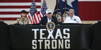 President Donald Trump and first lady Melania Trump with Texas governor Greg Abbott sitting at a table that reads, "Texas Strong"