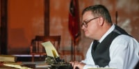 Anthony Smith sits with a typewriter 