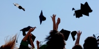 graduates throwing their caps in the sky
