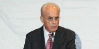 John MacArthur speaks at a podium on stage
