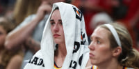 Caitlin Clark sits with a towel over her head