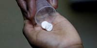 A nurse dispenses an anti-retroviral drug to a child in Kenya