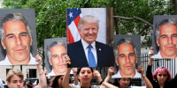 A group of young protesters holds pictures of Jeffrey Epstein and Donald Trump.