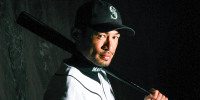 Ichiro Suzuki poses holding a baseball bat in his Mariners uniform