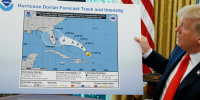 Donald Trump holds a NOAA map,.