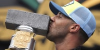 Image: Bubba Wallace kisses the trophy after winning a NASCAR Cup Series auto race at Indianapolis Motor Speedway, Sunday, July 27, 2025, in Indianapolis.