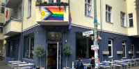 Exterior view of the 'Das Hoven' cafe, and LGBTQ flag is draped on the front