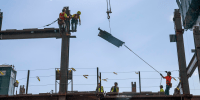 Iron workers position themselves to connect an iron strut on July 30, 2025, in Brooklyn, N.Y.