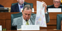 Terry M. Wilson looks through maps during a public hearing