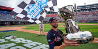 Eli White holds a trophy on the field
