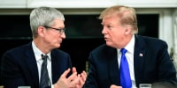 Tim Cook, left, and Donald Trump speak while seated at a table at the White House