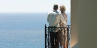 Senior couple on balcony overlooking ocean
