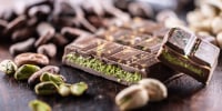 Dubai Chocolate bar with green kadayif and pistachio spread with pistachio nuts - close up