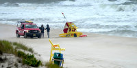 Lifeguards gather near East Goodrich Avenue in Long Beach Township, NJ, as waves crash into the coastline Monday morning, August