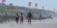 Red flags, indicating swimming is prohibited, are raised at the beach in Duck, N.C., on Aug. 19, 2025.