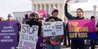 Demonstrators hold signs outside the Supreme Court