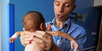 Palestinian doctor Ahmed Basal examines a child for malnutrition at Al-Rantisi Hospital in Gaza City