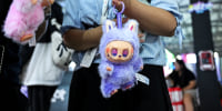 A woman holding a purple Labubu