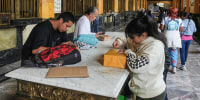 People prepare packages inside of the hall of a post office