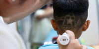 Hair salon owner Xueru gives a child a haircut in a design of a tank to commemorate the 80th anniversary of the end of World War Two in Beijing