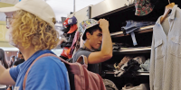 A student tries on a hat at NYU's Swap Shop.