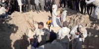 In this image taken from video provided by Rudaw TV, workers dig out human remains at the Khasfa site near the northern Iraqi city of Mosul, where authorities have begun excavating a mass grave believed to contain thousands of victims of the Islamic State.
