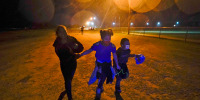 Young migrants hold hands as they run in the rain at an intake area after turning themselves in upon crossing the U.S.-Mexico border in Roma, Texas, in 2021.