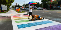 Activists use chalk to restore color to a rainbow crosswalk that the Florida Department of Transportation erased in Orlando, Fla.
