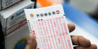 A hand holds a number slip lottery ticket
