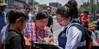 People in Guatemala check on a list.