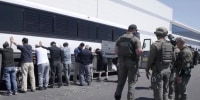 manufacturing plant employees waiting to have their legs shackled at the Hyundai Motor Group’s electric vehicle plant