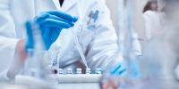 Chemist filling vials in experiment at laboratory