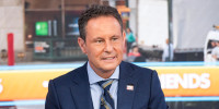 Brian Kilmeade sits on a couch on set