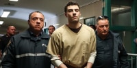 Luigi Mangione, accused of the murder of United Healthcare CEO Brian Thompson, is escorted by police as he arrives at court in New York City on September 16, 2025. 