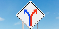 Photo illustration of a road sign with two arrows, red and blue, diverging 