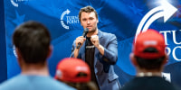 Charlie Kirk speaks in front of an audience on stage