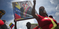A man holds a portrait of Venezuelan President Nicolas Maduro during a march in support of him in Caracas on Sept. 23, 2025. 