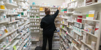 A pharmacy tech looks for a drug on a shelf at a pharmacy in Provo, Utah, on Aug. 7, 2025. 