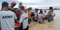 Nepalese army personnel transport survivors in a body of water