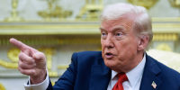 Donald Trump speaks and points while seated
