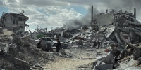 Smoke rises as people walk amid the rubble of destroyed buildings in Khan Yunis, southern Gaza Strip, on October 10, 2025.
