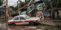 Neighbors gather around a damaged house after heavy rainfall in Poza Rica, Veracruz state, Mexico, Saturday, Oct. 11, 2025.