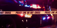 Two police officers behind crime scene tape