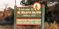 The sign for Saint Helena Island on the side of a two way road