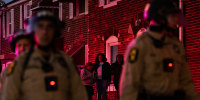 Illinois State police with crowd control gear stand guard outside of homes across from the Broadview ICE facility in Broadview, IL on Saturday, October 11, 2025 