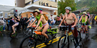 Participants in the Emergency World Naked Bike Ride pass by the U.S. Immigration and Customs Enforcement building.