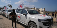 A masked Hamas gunman stands next to Red Cross vehicles arriving for the handover of Israeli hostages by in Khan Younis, southern Gaza Strip, Monday, Oct. 13, 2025.