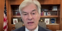 Mehmet Oz speaks while seated in an office