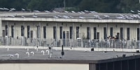 People on a balcony of a building with what appears to be Starlink satellite dishes