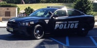 A Franklin Township Police vehicle is parked outside near a field.